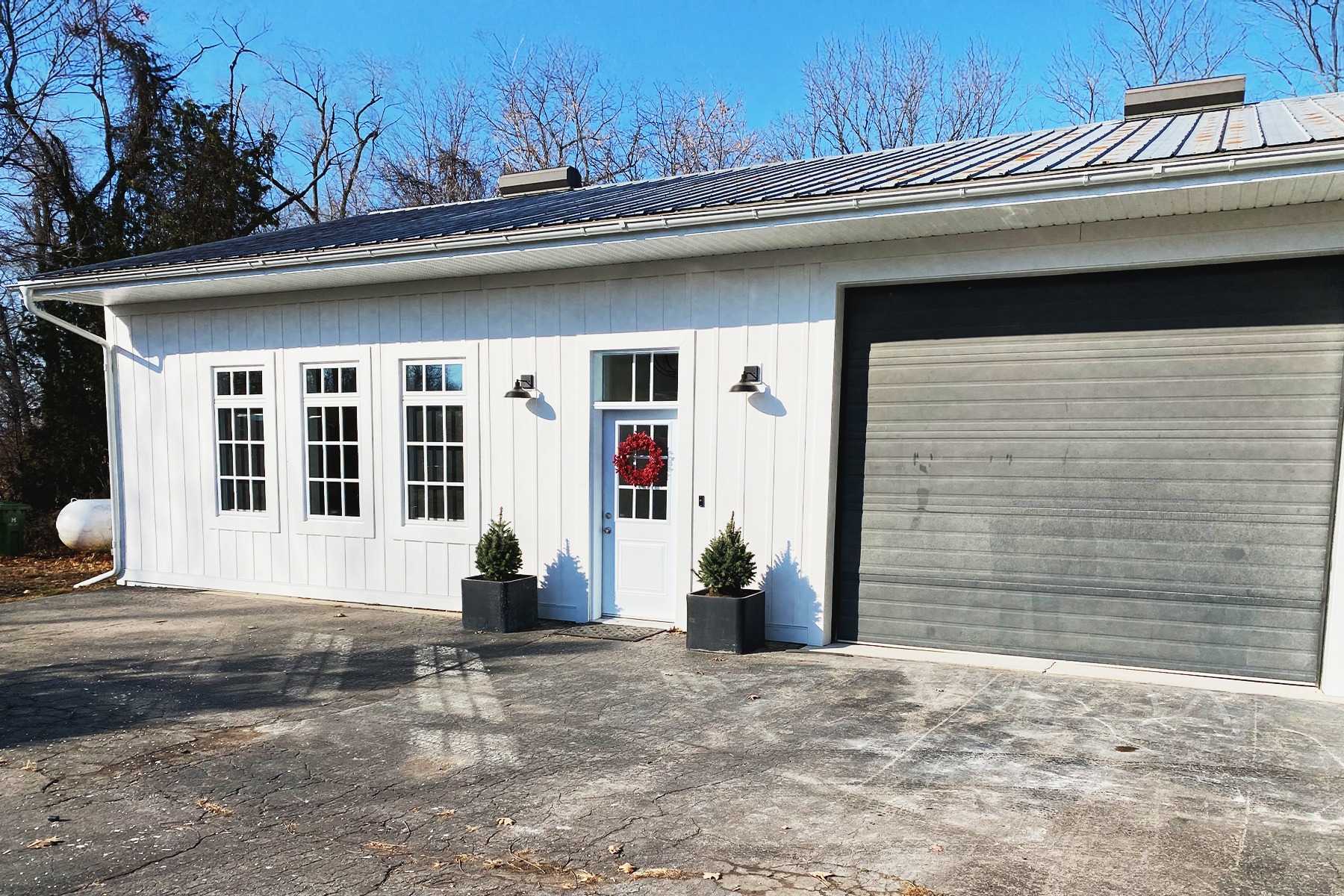 A cut off view of a single-story work shop showing halve the garage door and office area.